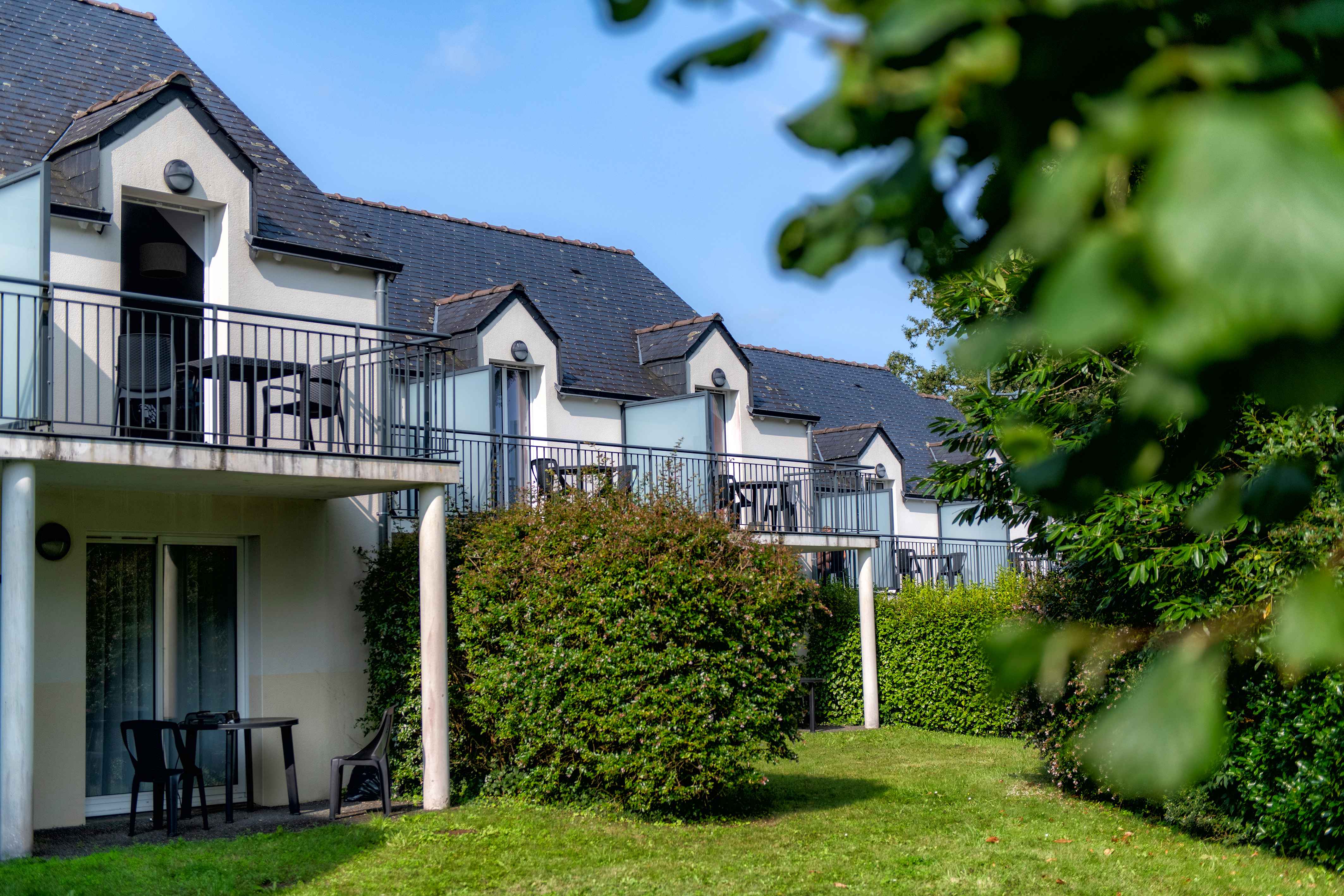 image Breton-style apartment blocks with private balconies, set among the trees of the private park surrounding the residence.