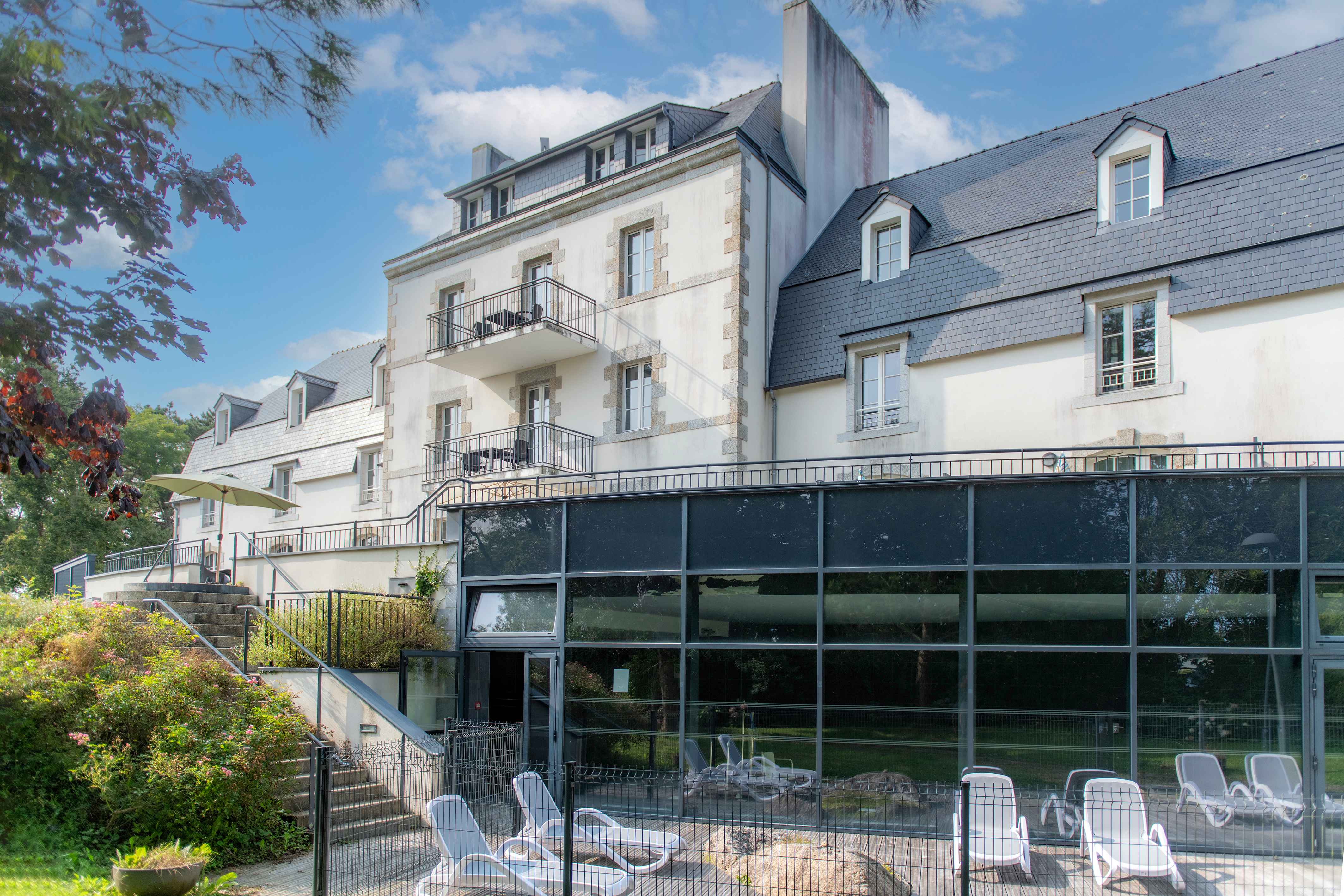 image Floor-to-ceiling glass connects the heated indoor pool to the green parkland outside — swimming whatever the weather.