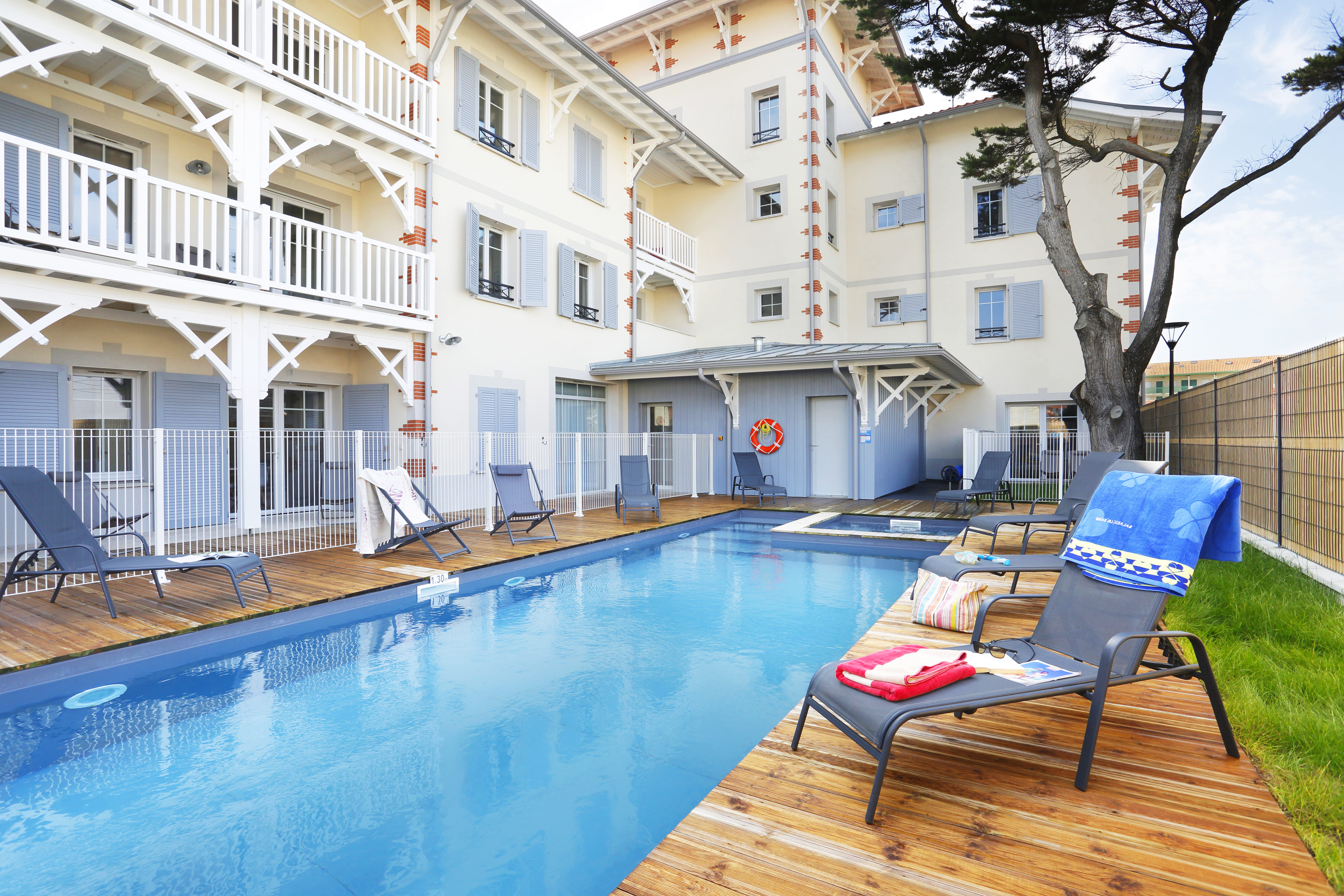 image Sunlight ripples across the pool water, with loungers set out for an afternoon in the sun.