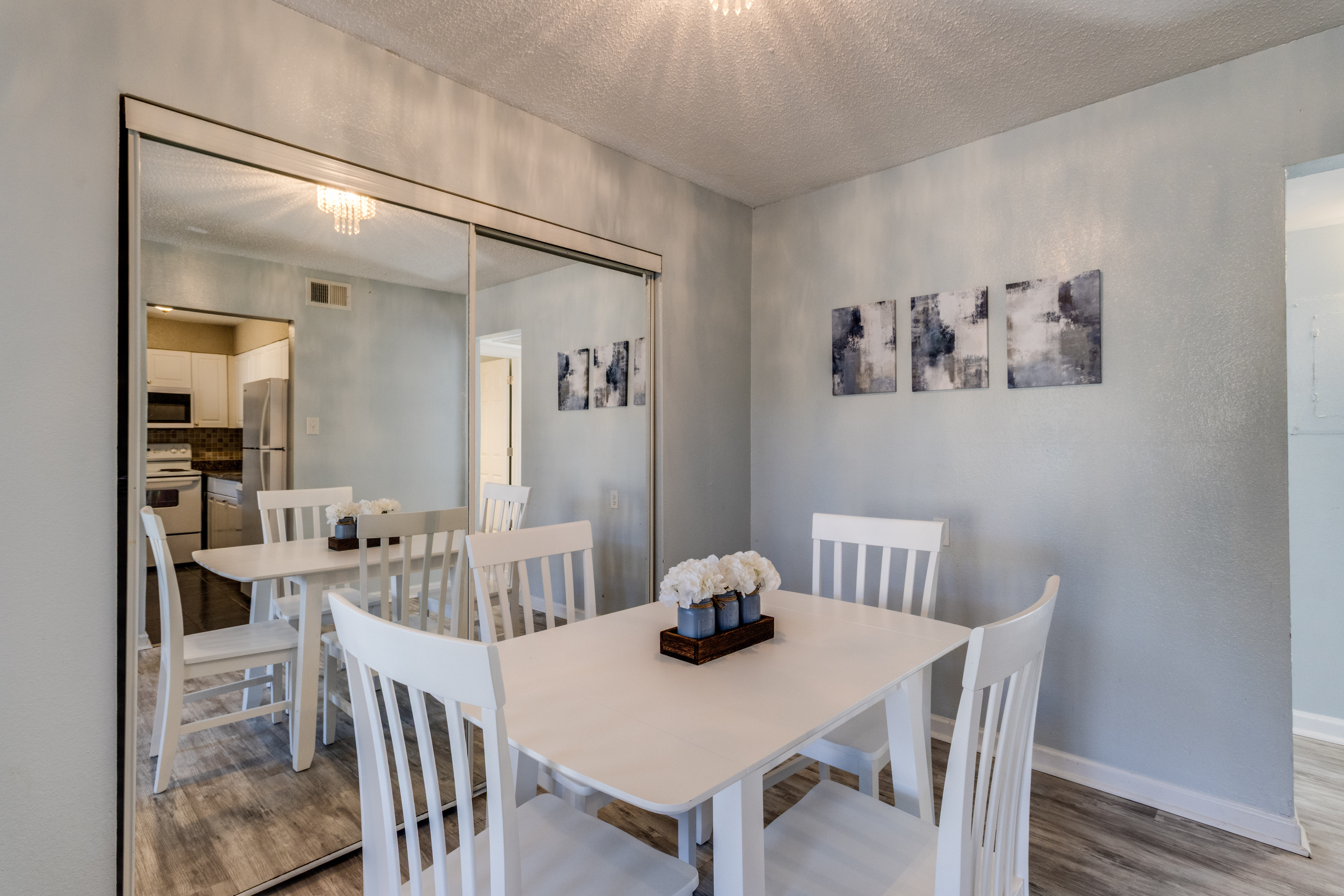 image Gather around the bright dining table set for memories, accompanied by chic artwork.