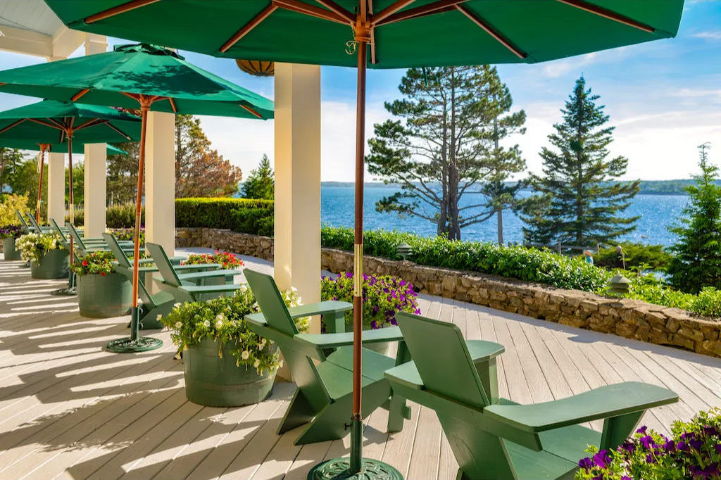 image Sip something cool beneath shady umbrellas while gazing out across calm waters and towering pines.