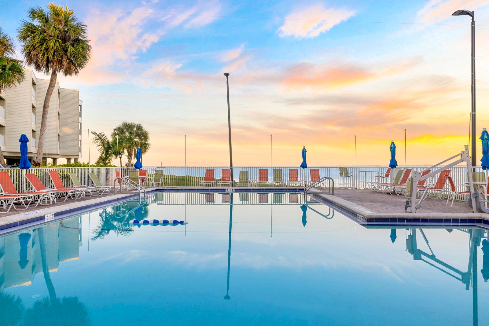 image Capture stunning sunset moments while lounging by the pool's clear waters.