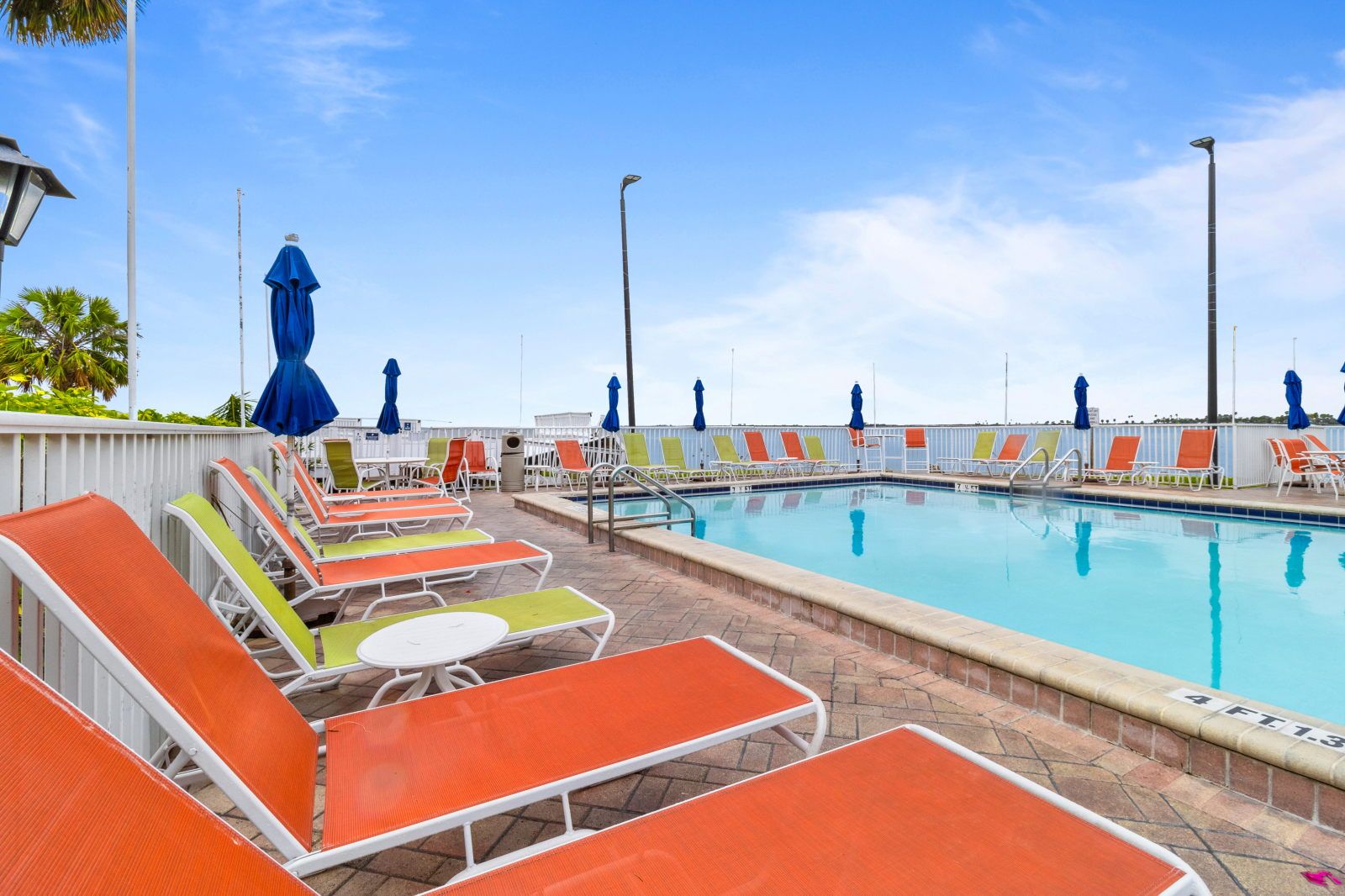 image Relax on colorful lounge chairs by the pool, a perfect spot to unwind and soak up the Florida sun.