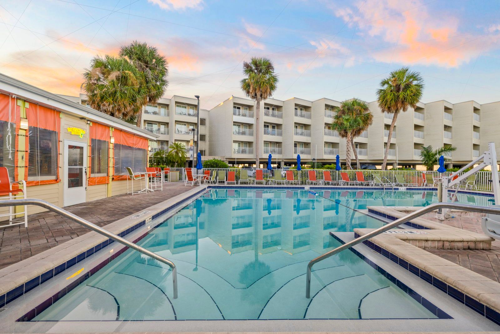 image Unwind under the setting sun with a drink at the poolside bar, just steps away.
