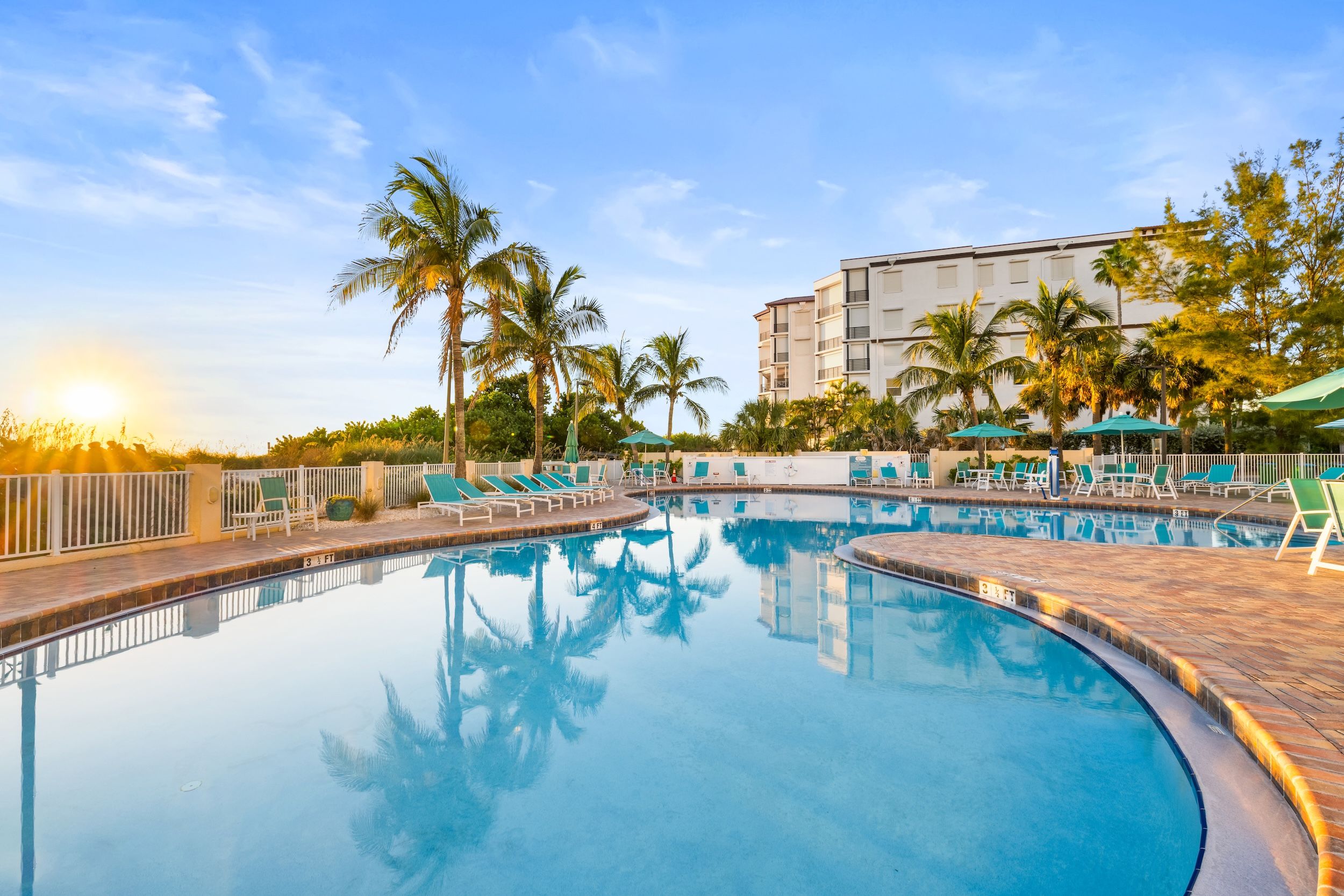 image Bask in the sun by the pool, where the flickering water reflects the golden hues of sunset.