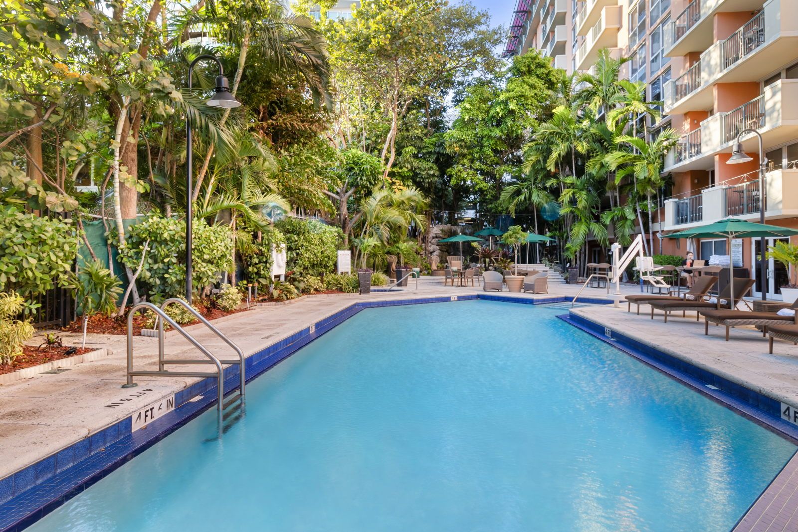 image Dive into the inviting pool, flanked by palm trees and relaxing lounges, ideal for soaking up the Florida sun.