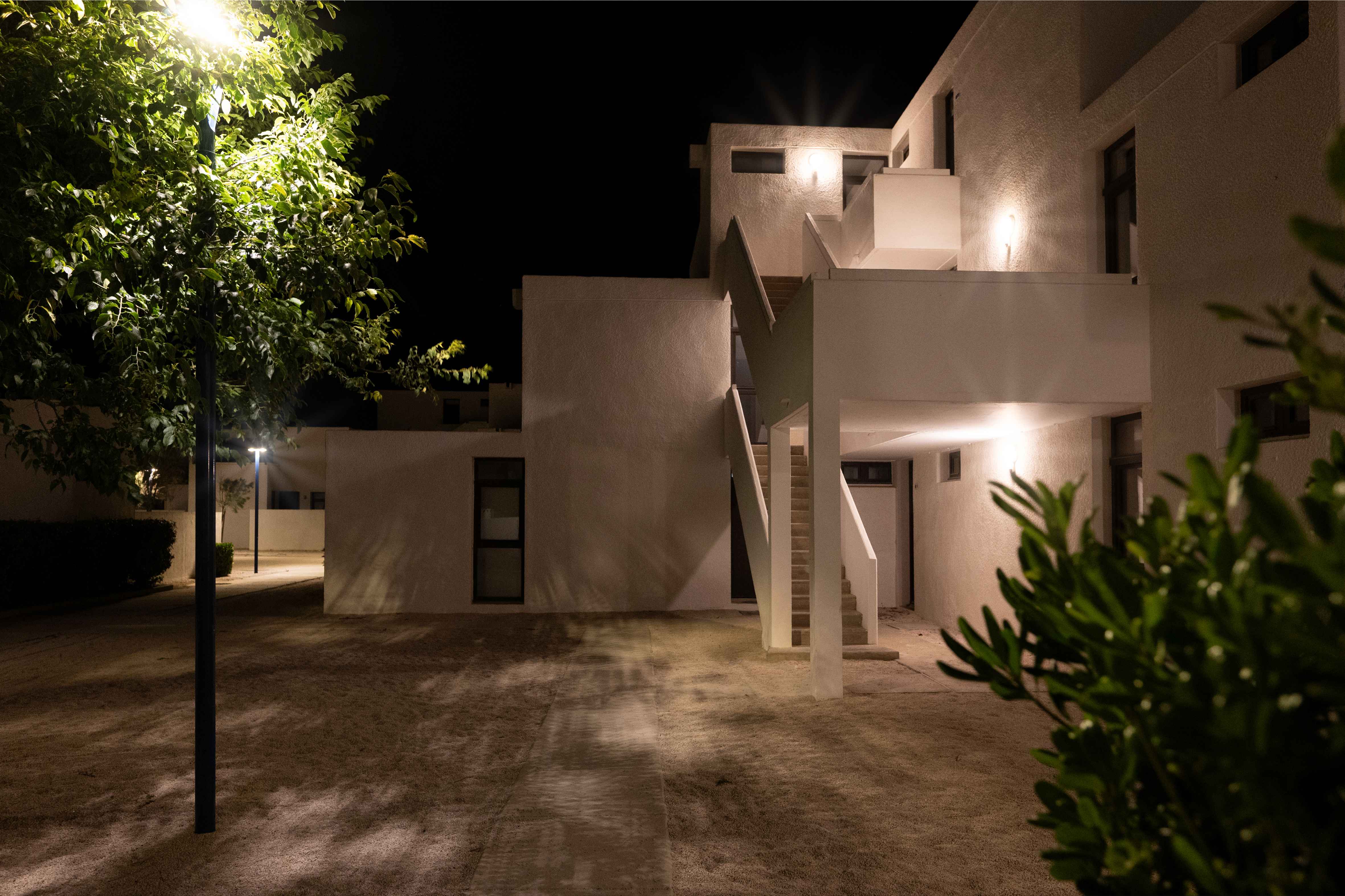 image The residence at night — white facades glowing under the stars, peaceful and car-free.