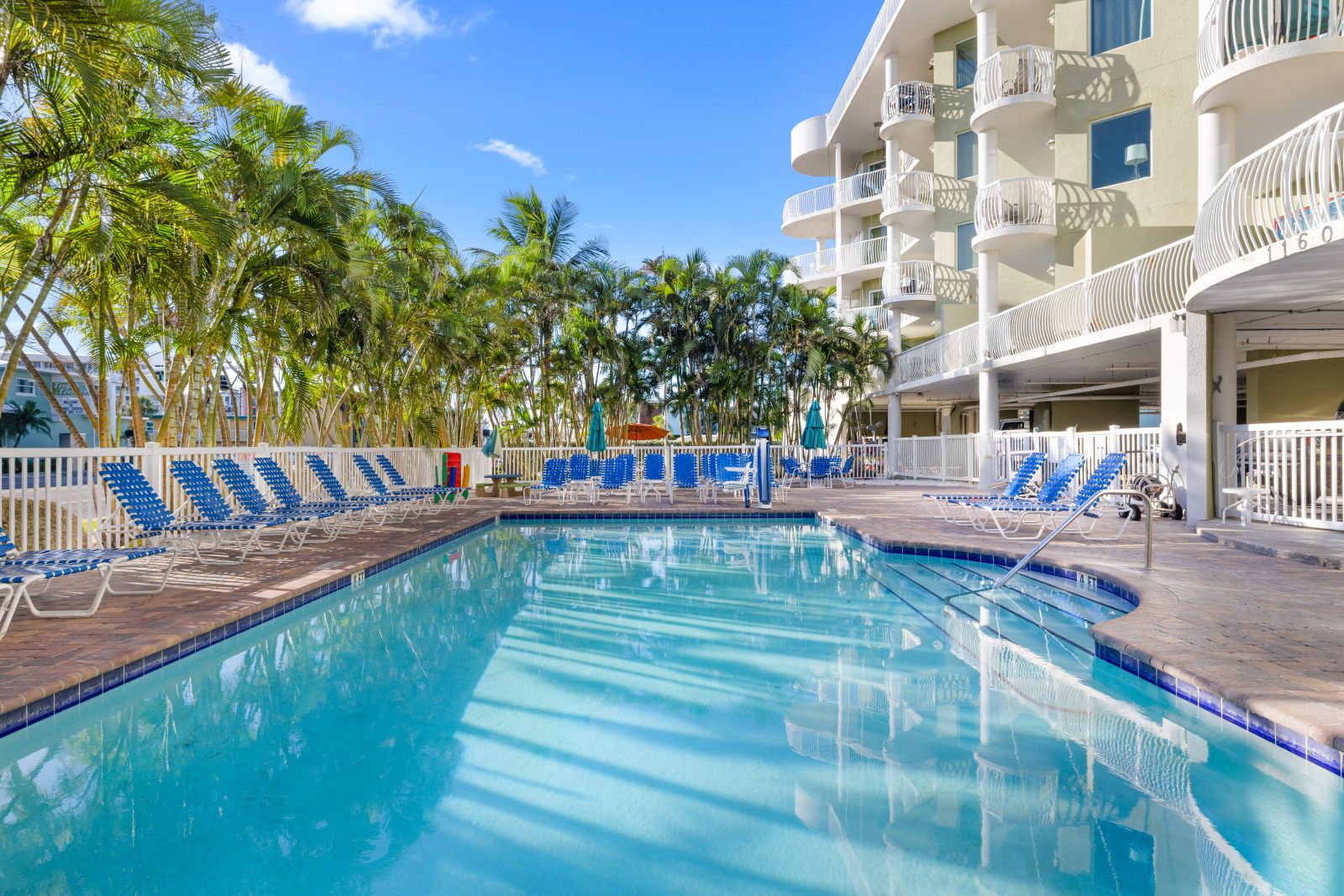 image Dive into a refreshing oasis, where palm trees sway gently beside the inviting pool.