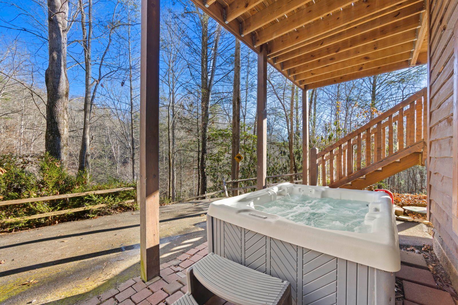 image Relax in the bubbling hot tub as you enjoy the peaceful ambiance of the surrounding trees.