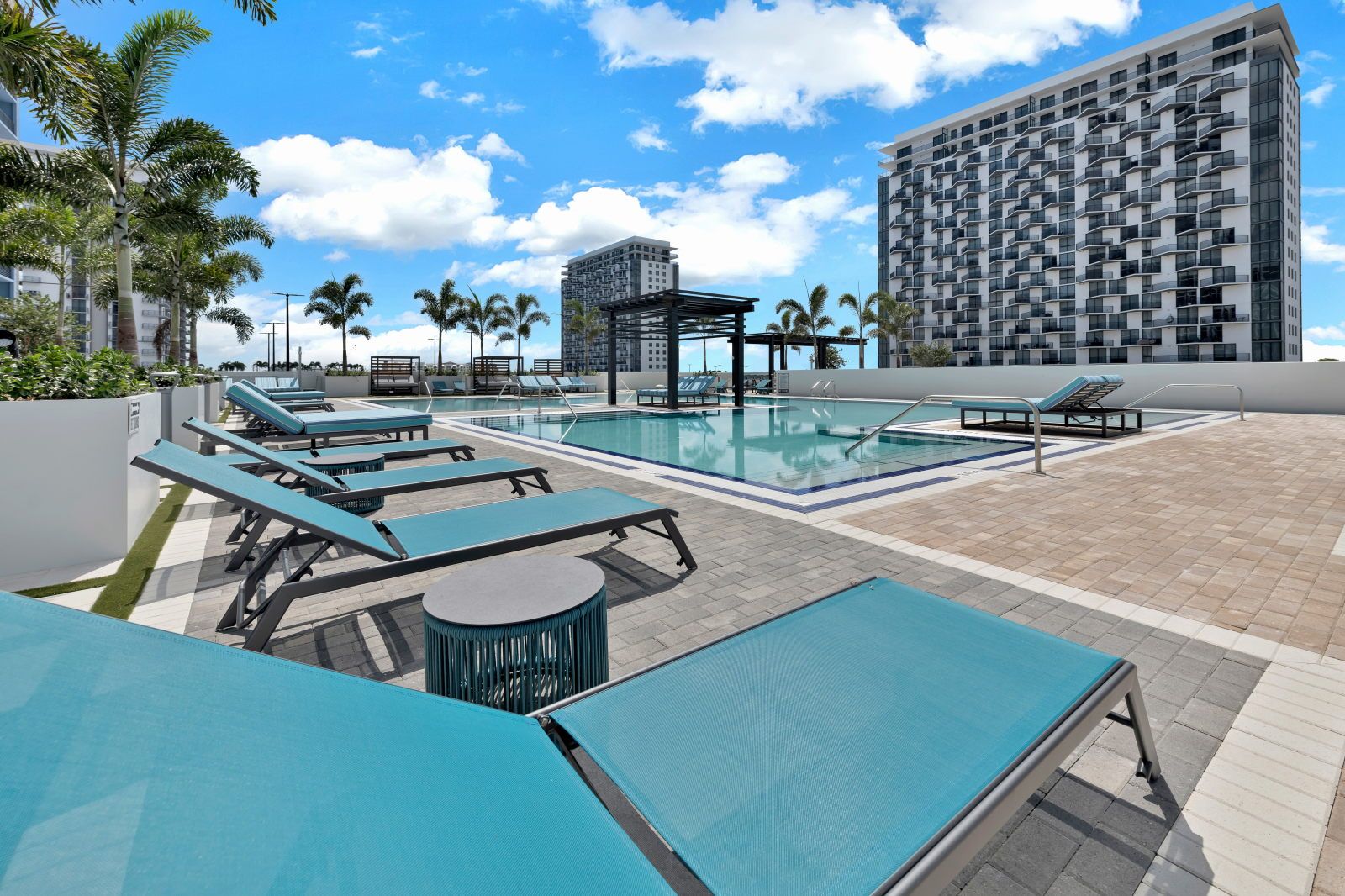 image Lounge in style beside the resort-style pool, with chic seating and modern architecture in view.