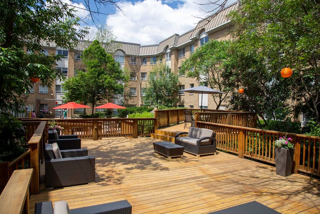 image Wooden deck with lounge chairs and red umbrella shading — the courtyard wraps around the hotel for outdoor breaks throughout the day.
