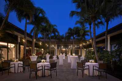 Twinkling lights on the poolside patio at dusk, with cushioned seating and room to linger