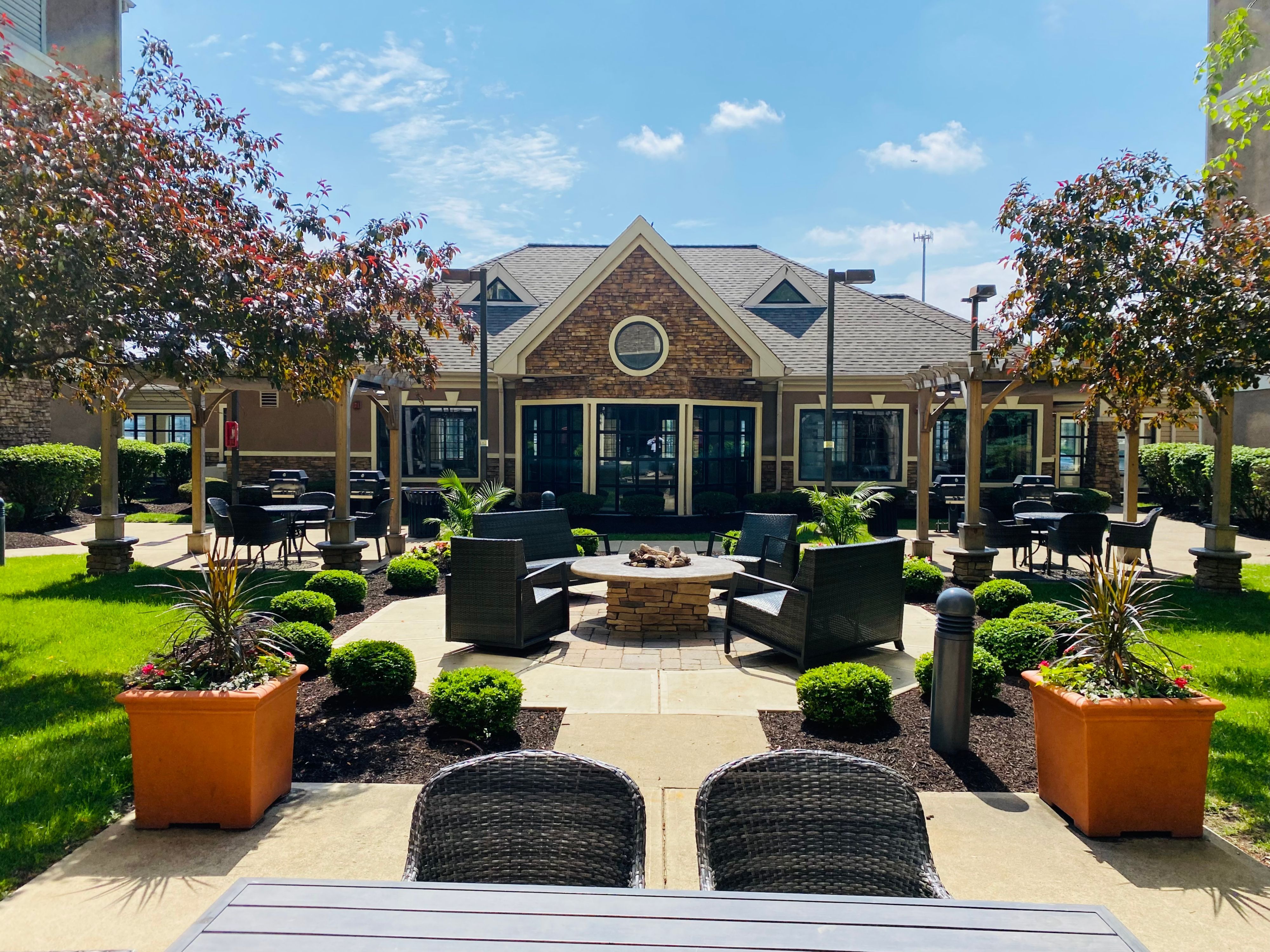 image Outdoor patio with comfortable seating surrounded by greenery.