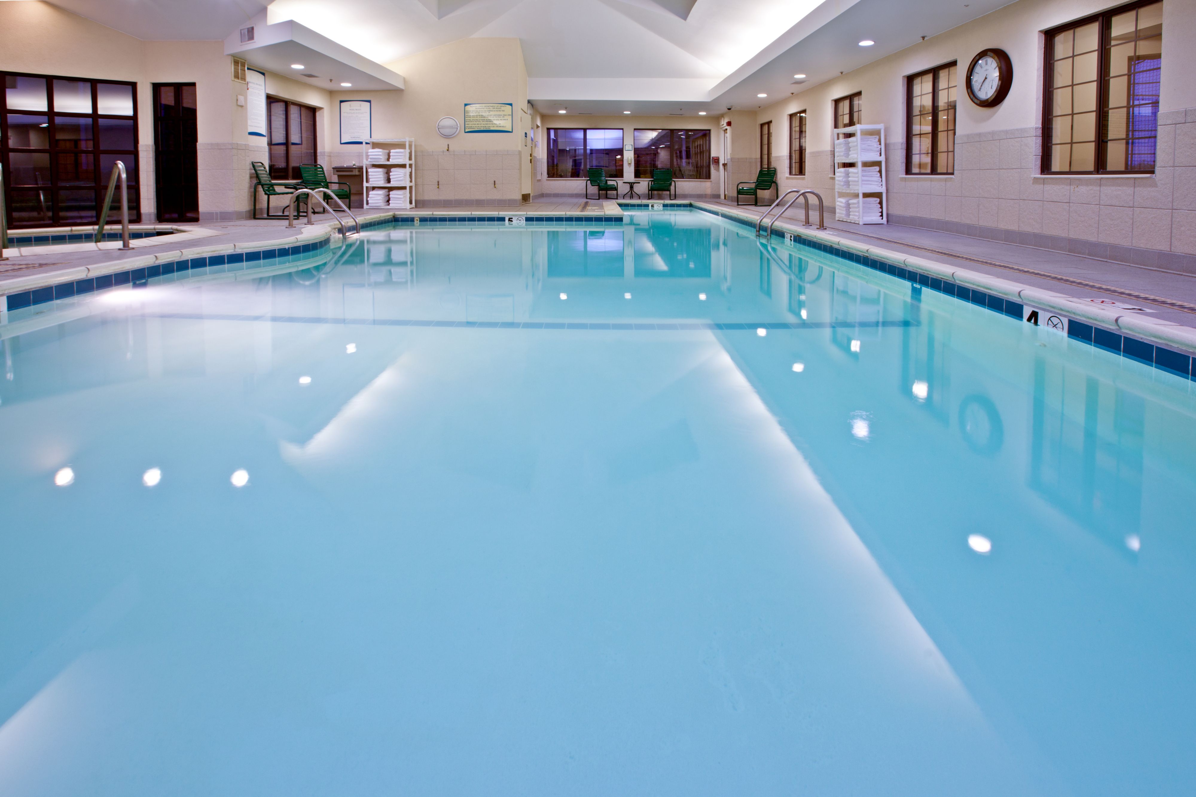 image Spacious indoor heated pool with calm, reflective water.