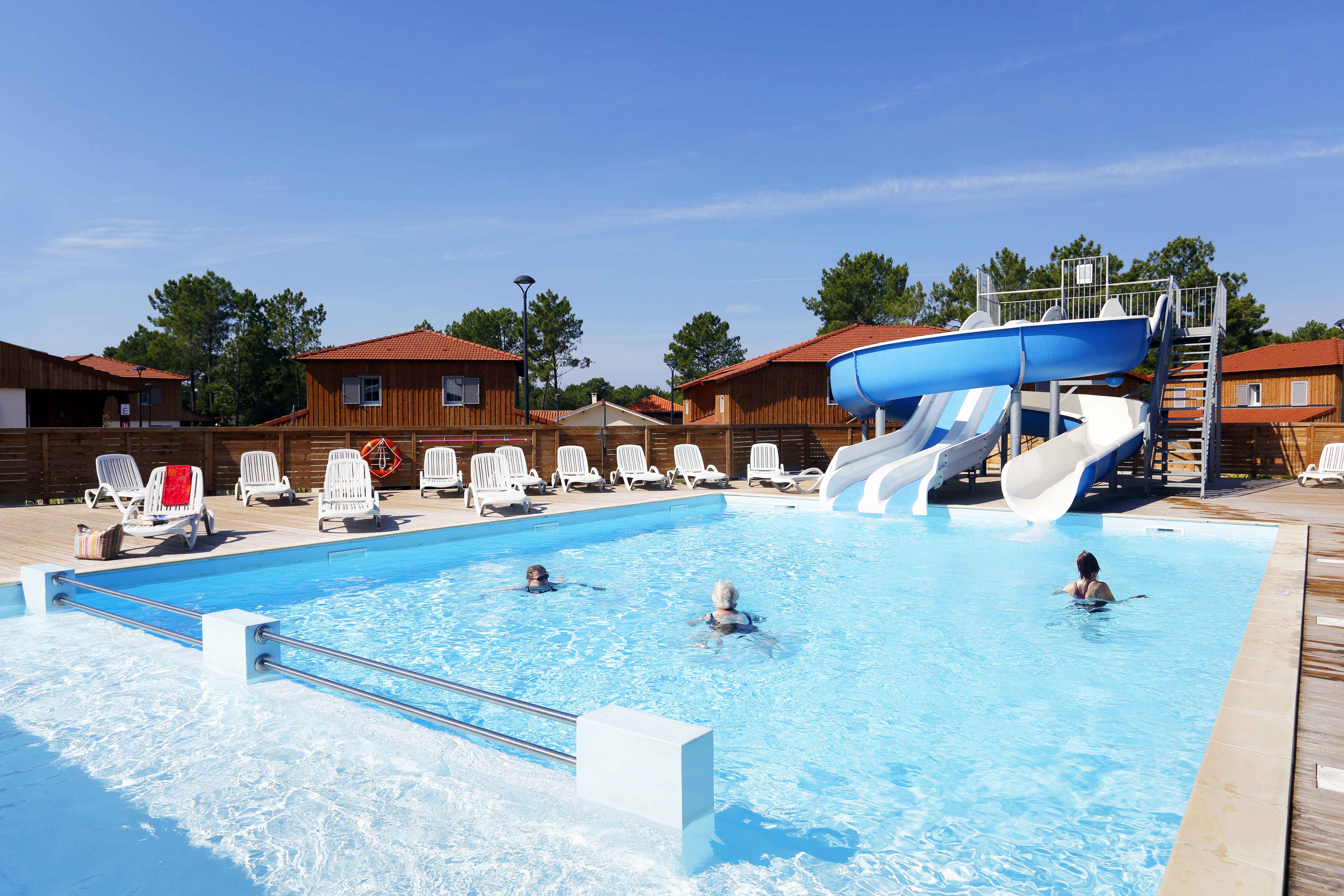 image Wide outdoor pool area surrounded by the 2-hectare pine forest — a green backdrop for a summer afternoon swim.