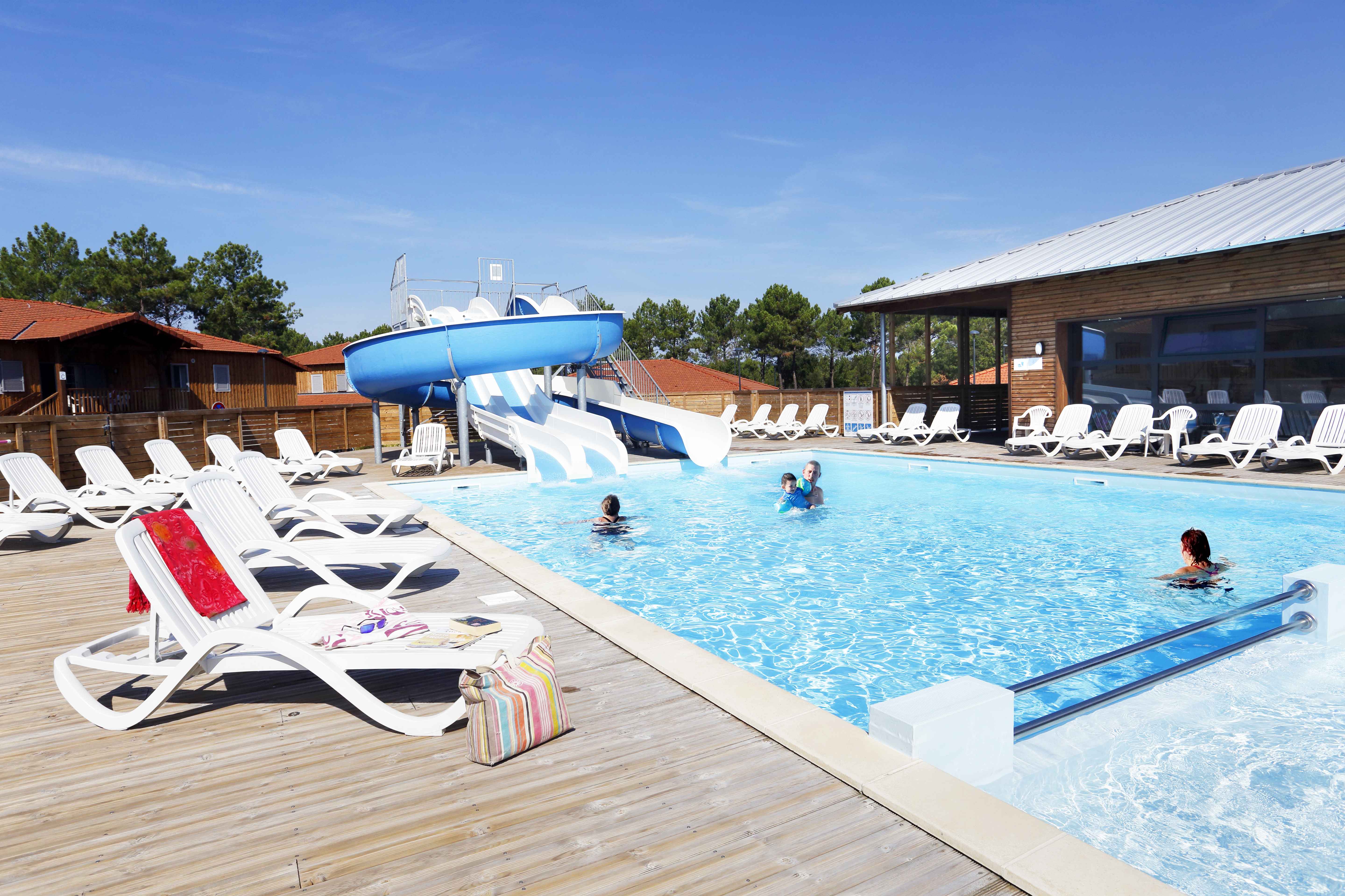 image The heated outdoor pool with water slide and children's pool — open April to September, just steps from the pine forest.
