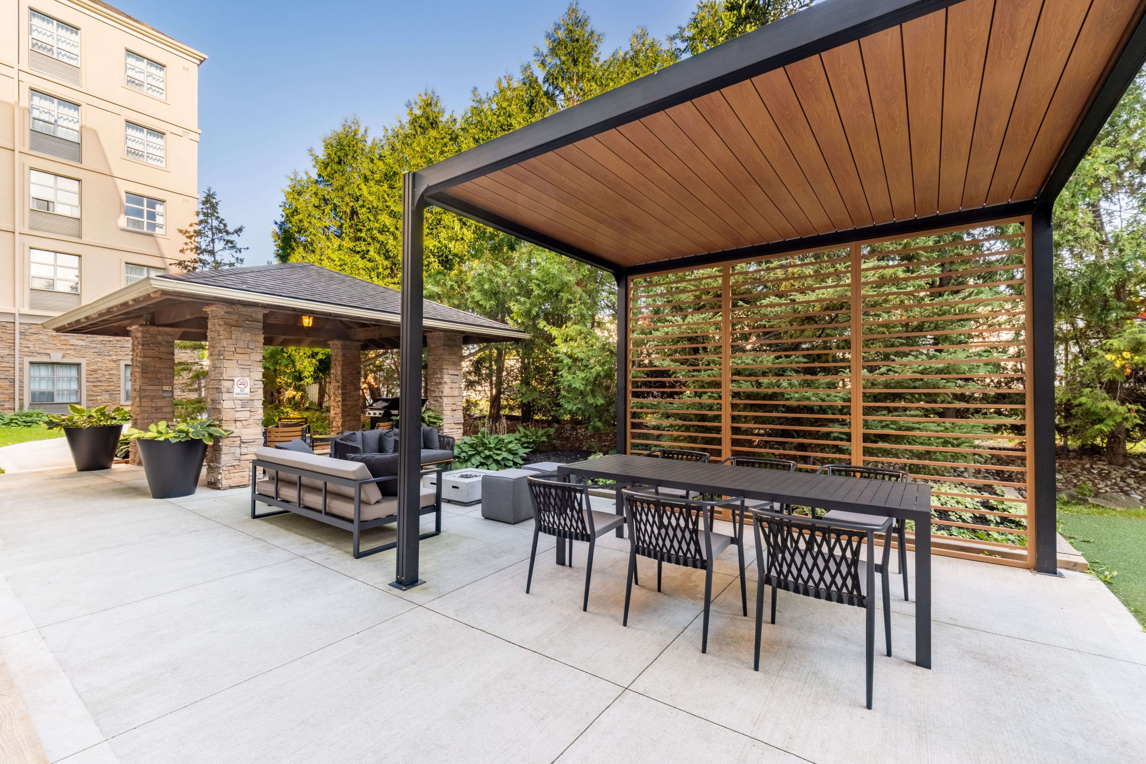 image Outdoor courtyard seating area with patio furniture and greenery.
