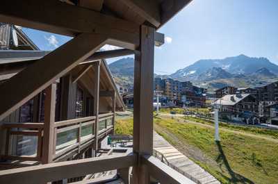 Wooden balconies facing the mountains, with summer trails starting close to the residence.