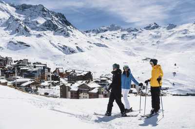 Skiers gathered with the snowy village rooftops behind them.
