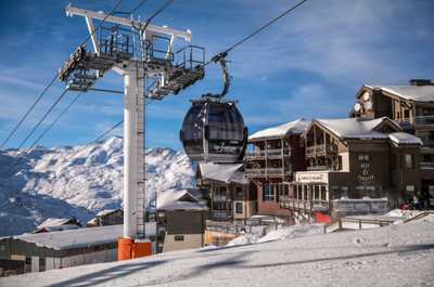 A gondola above the snow-covered buildings of the village.