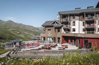 Terrace tables facing the mountains, a summer lunch spot in Val Thorens.