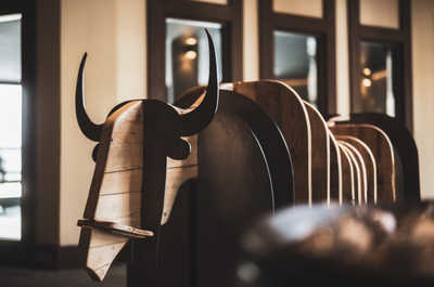 Carved wood details and warm amber lighting carry the Kashmir-inspired theme through the shared lounge spaces.