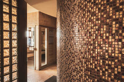 Mosaic-tiled sauna walls and dry heat await after a morning of mountain biking — open access, no booking required.