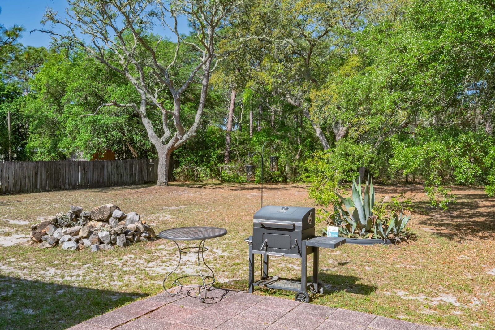 image Backyard charcoal grill and fire pit with a stone surround — fire it up after a morning out on the water