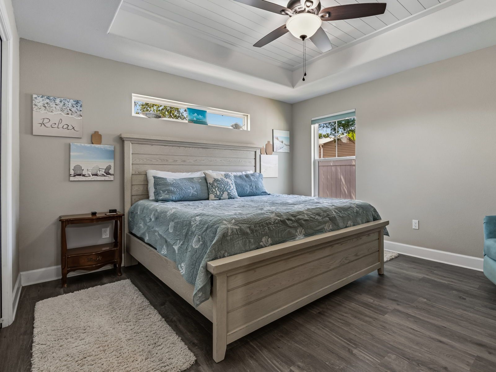 image Bedroom with queen bed, light blue quilt, windows on both sides, plush rug, and soft neutral walls