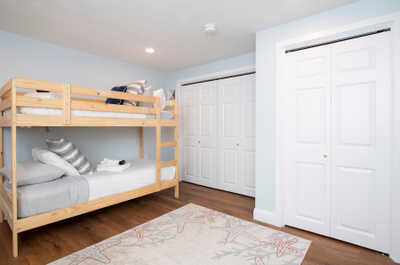 Rest easy in this light-filled room, featuring inviting bunk beds and a whimsical starfish-patterned rug.