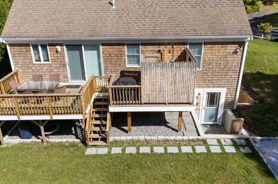 Relax on the spacious deck, equipped for outdoor dining, surrounded by lush greenery and a peaceful atmosphere.