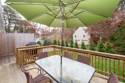 Relax under the green umbrella while enjoying outdoor meals on the spacious deck.