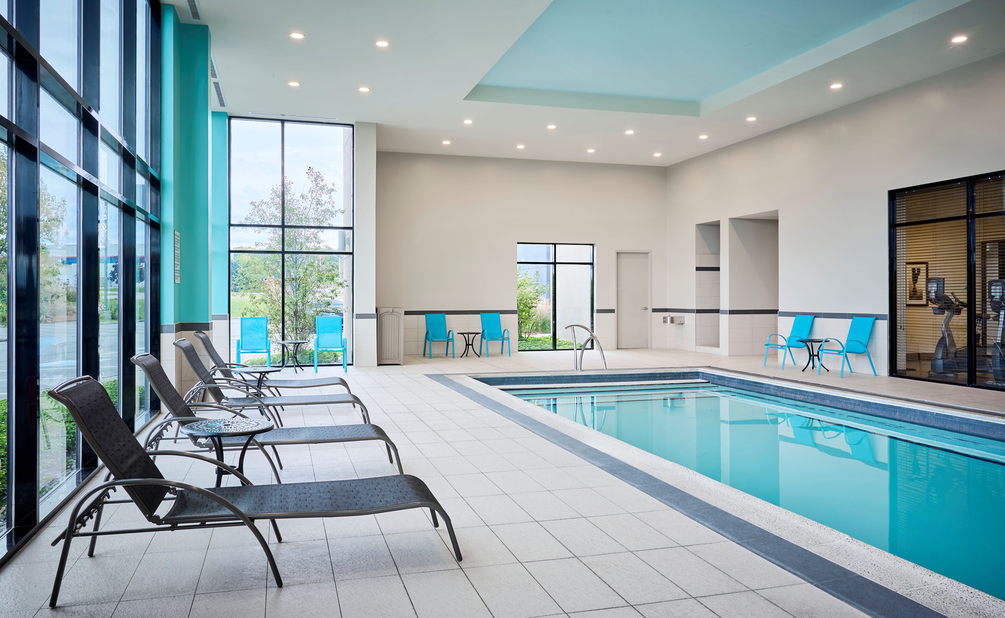 image Pool deck with lounge chairs and large windows.