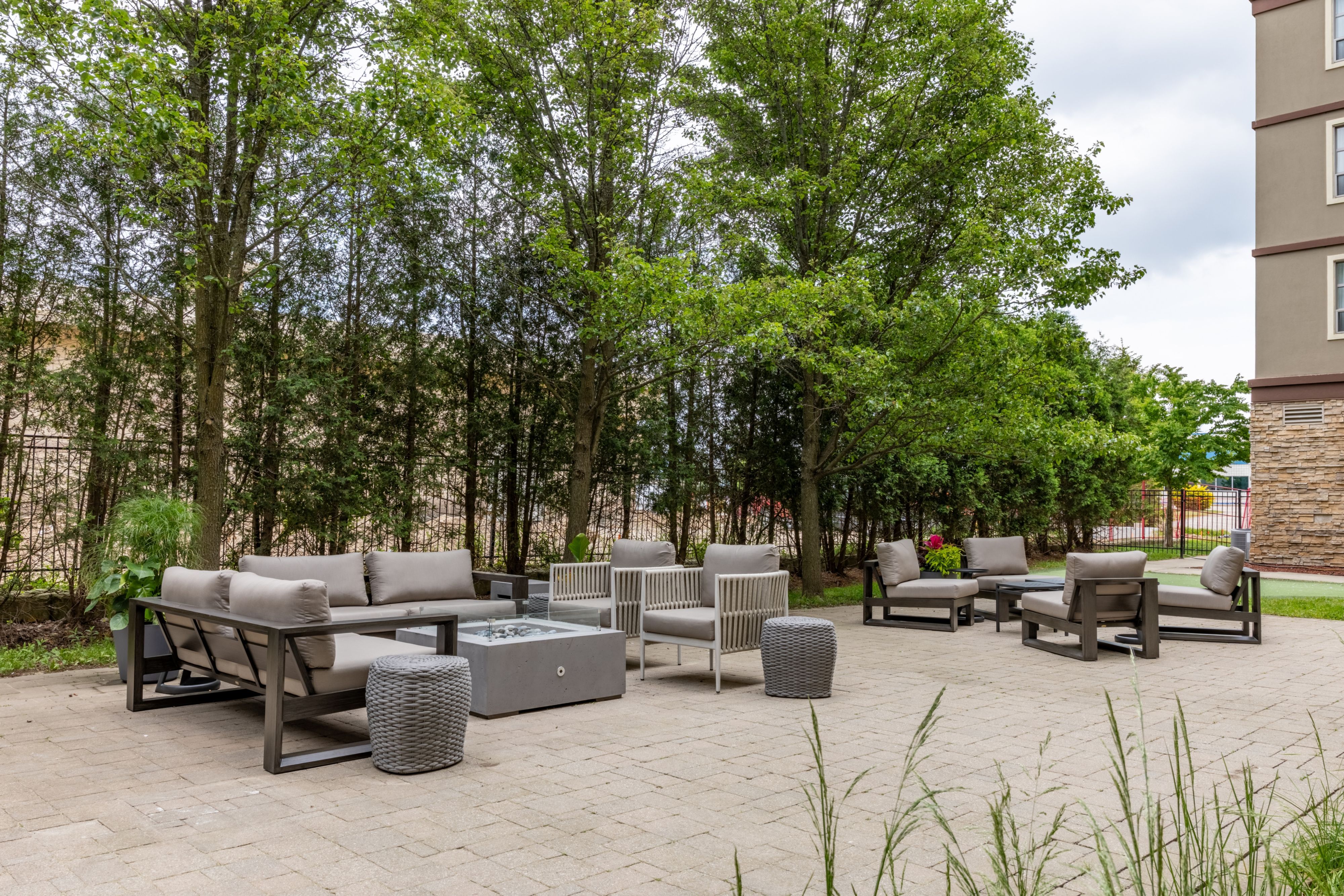image Cosy outdoor lounge with cushioned sectional seating and paved terrace.