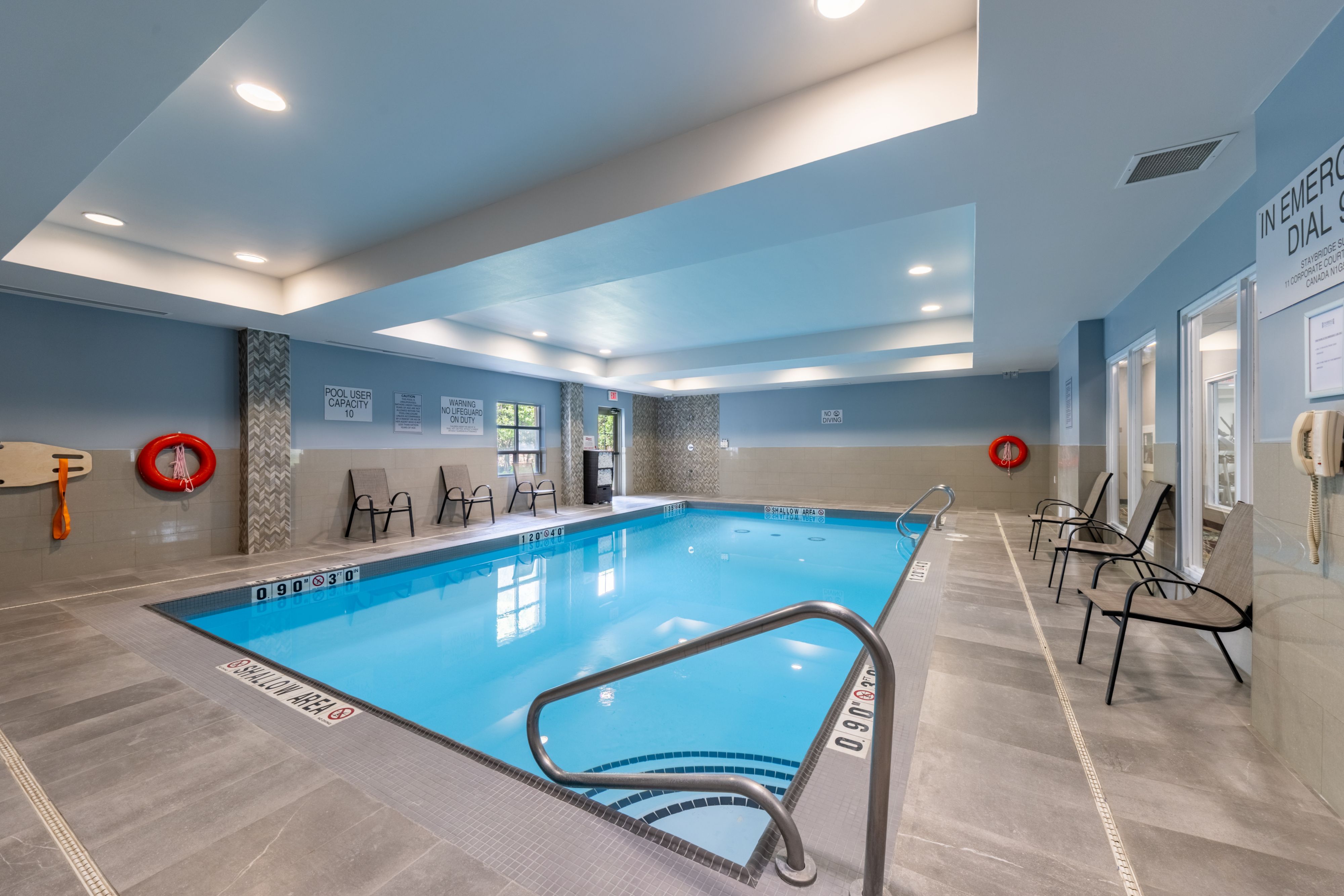 image Indoor heated pool with accessible steps, handrails, and pool safety signage.