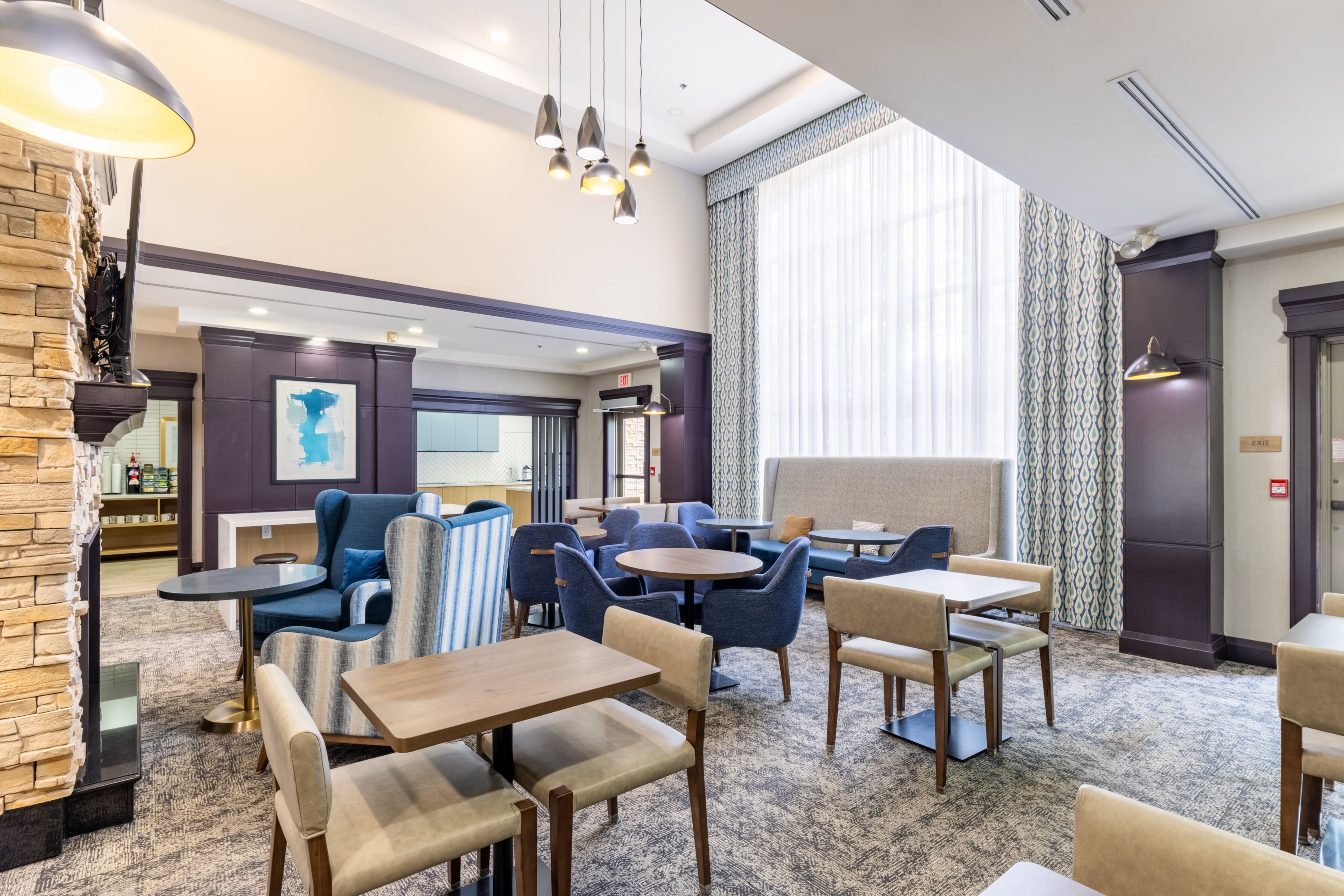 image Inviting dining lounge with fireplace, colourful seating, and artwork.