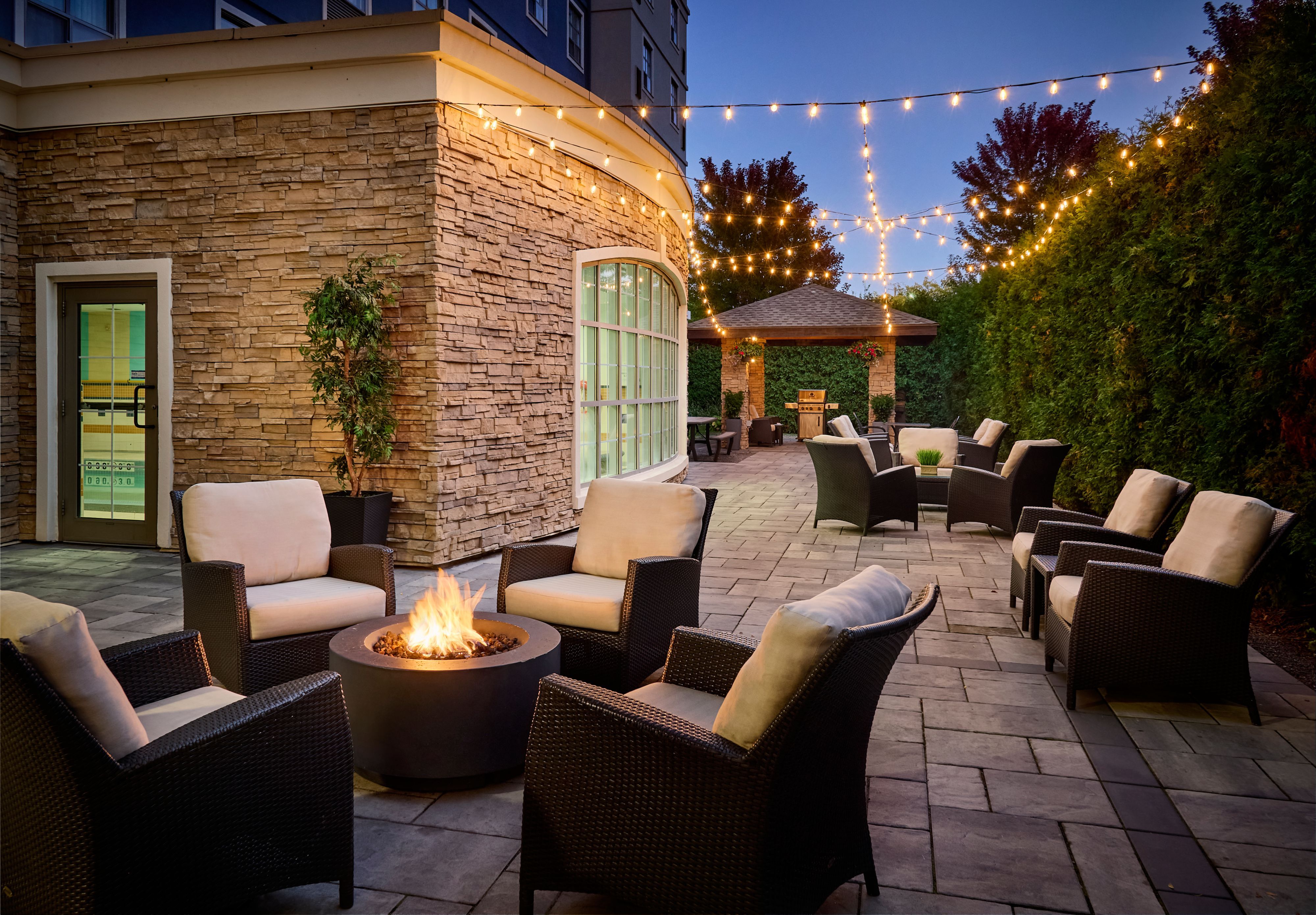 image Cozy outdoor patio with a fire pit and string lights.