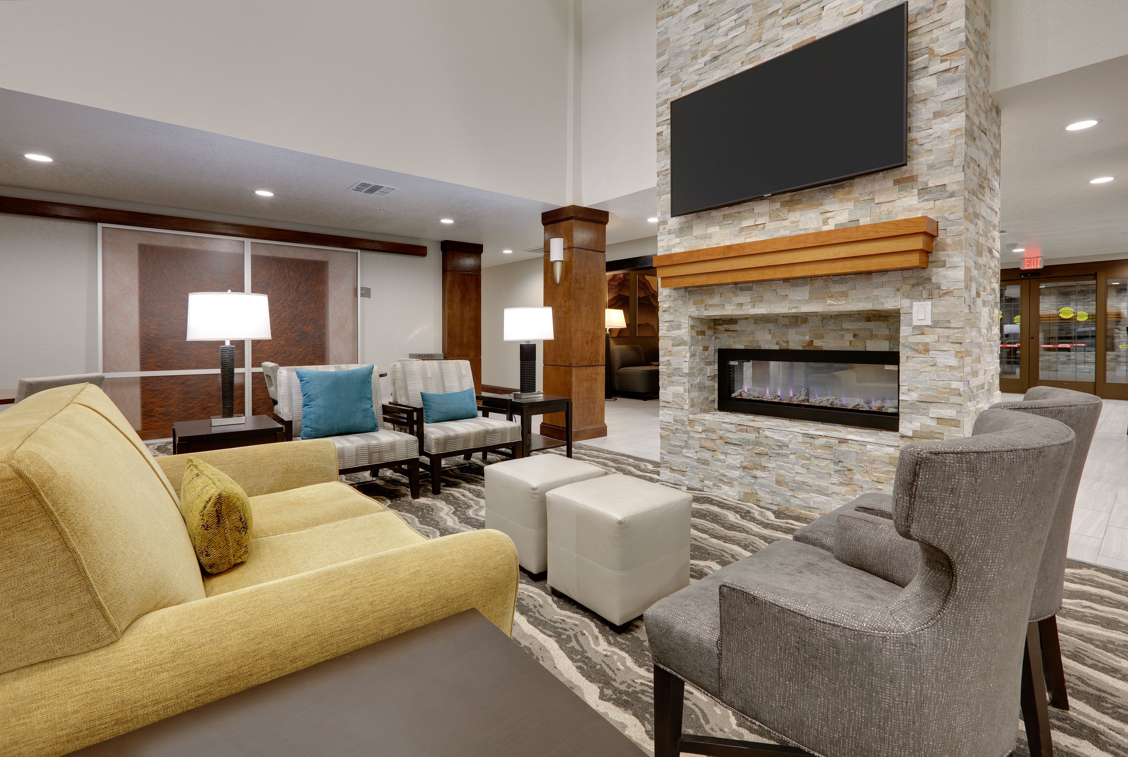 image Cozy lobby seating area featuring a decorative fireplace and television.