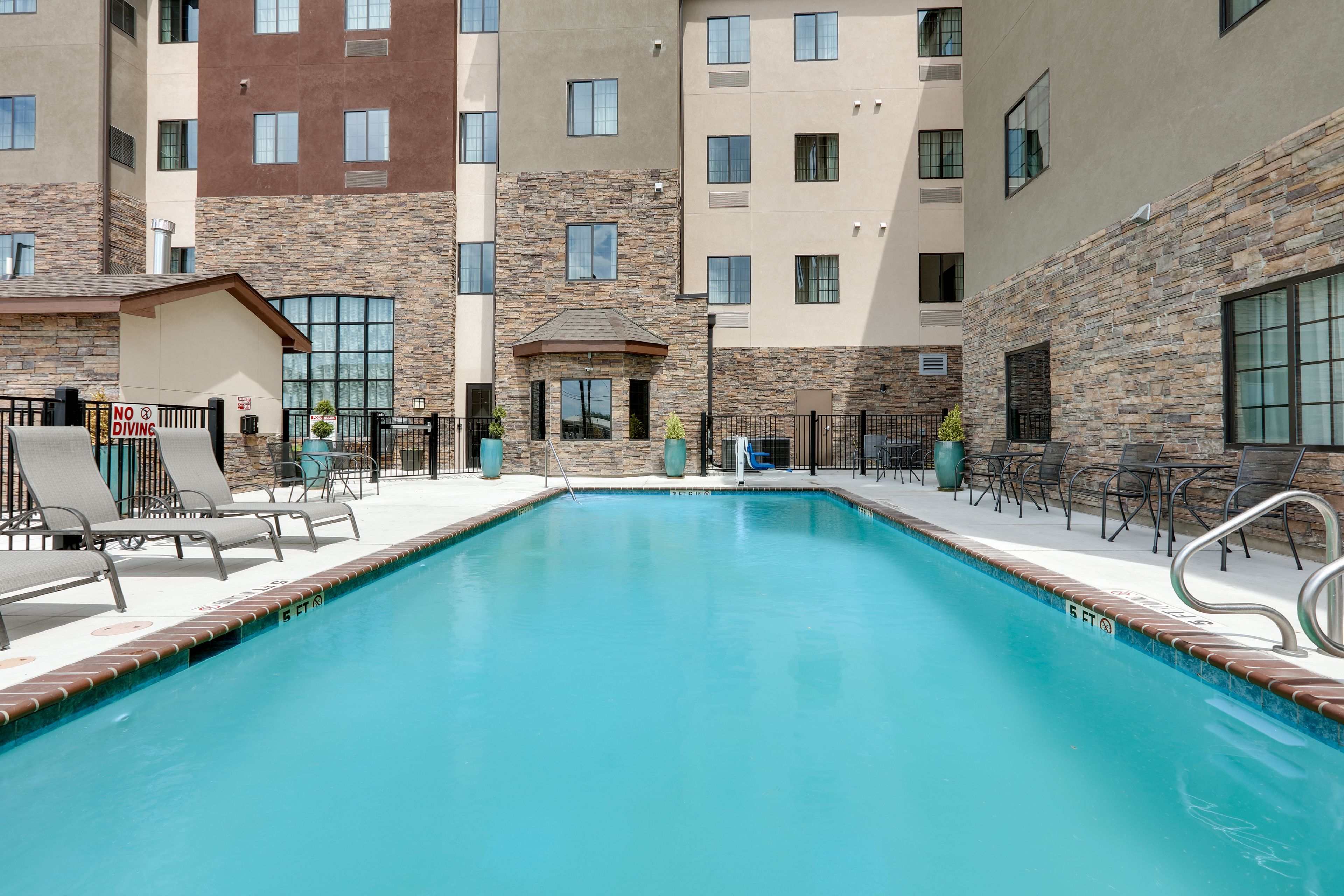 image A shimmering pool bordered by lounge chairs invites relaxation and fun.