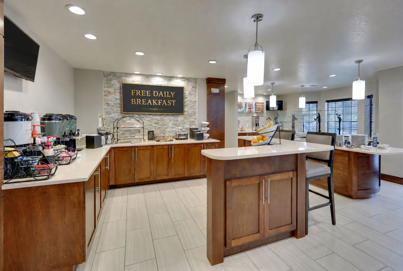 image Free Daily Breakfast! A dining area showcases a buffet setup with fresh fruit.
