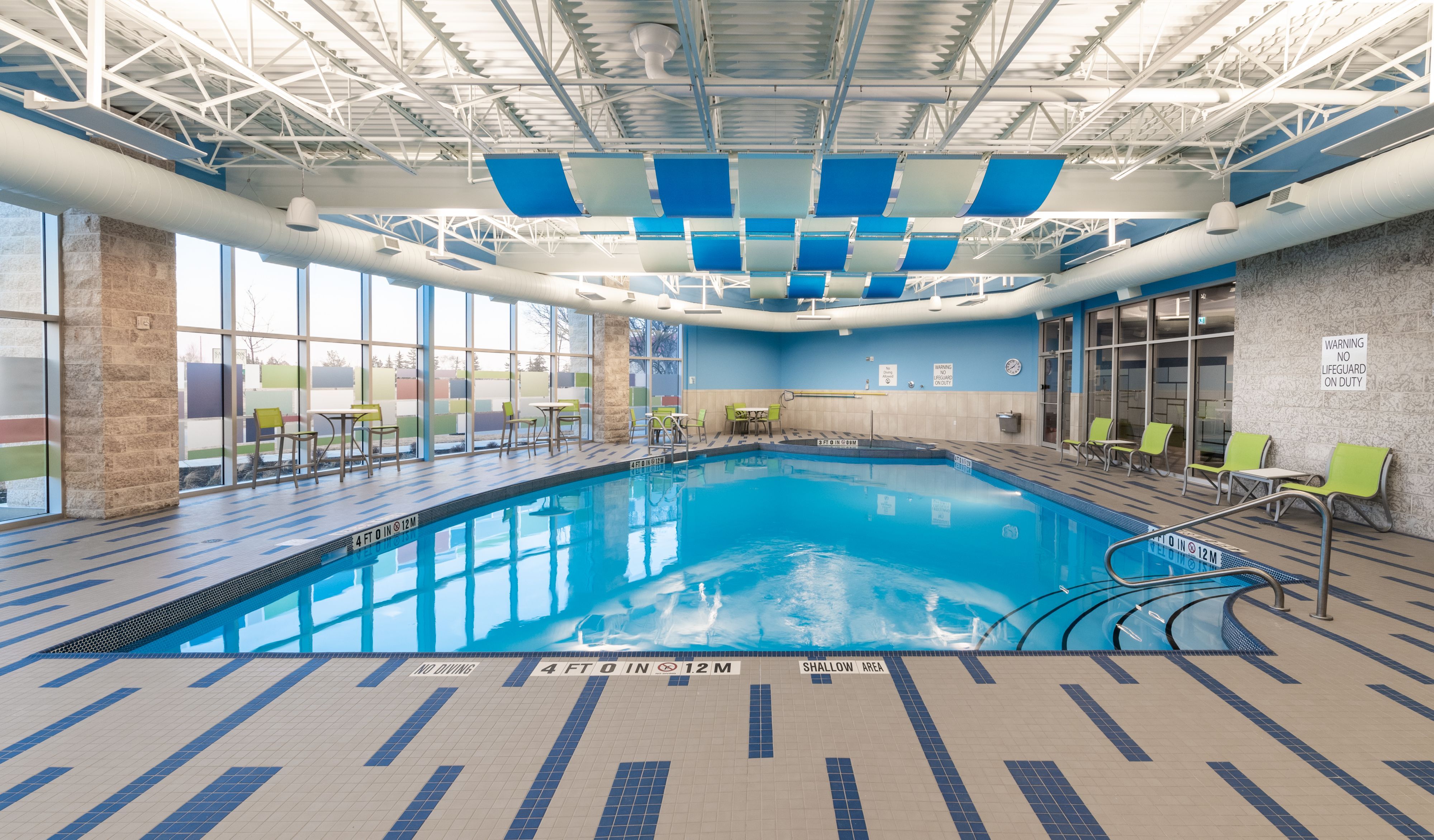 image Sparkling indoor pool with clear water and comfortable poolside seating.