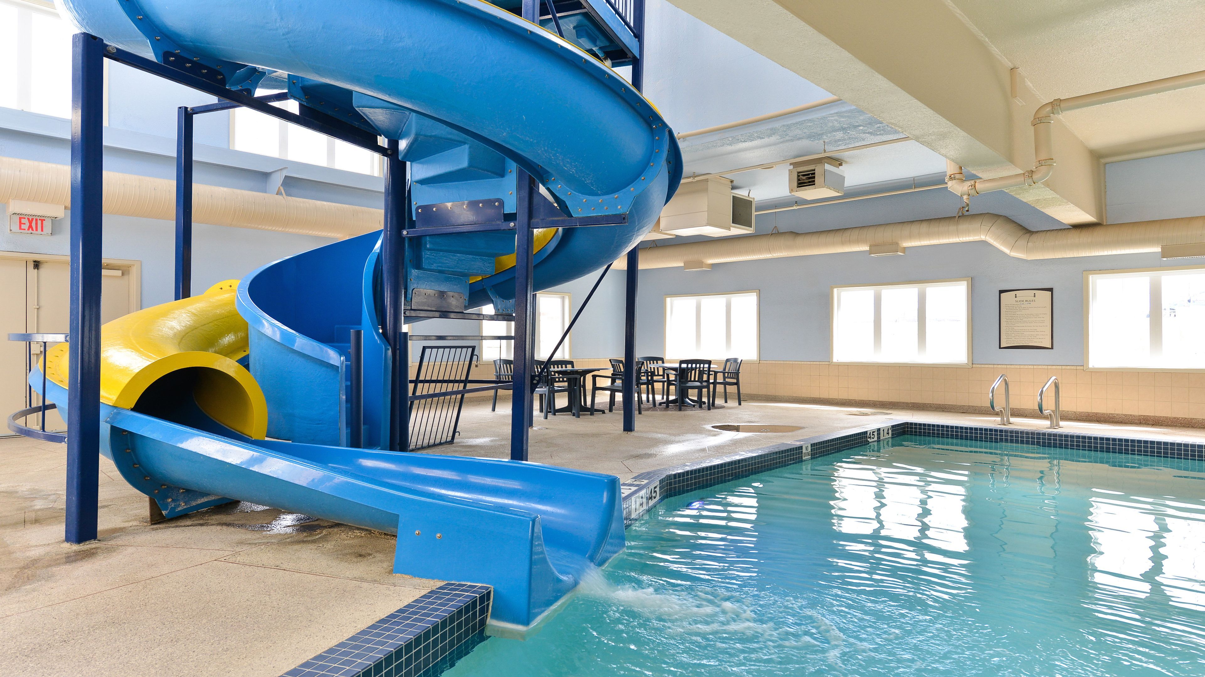 image Splash into fun on an indoor waterslide towering over a sparkling pool.