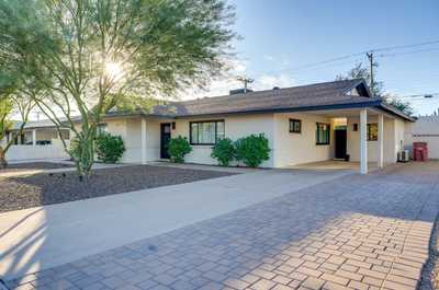 Welcome home to a modern exterior with beautiful landscaping and a warm sunlit entryway.