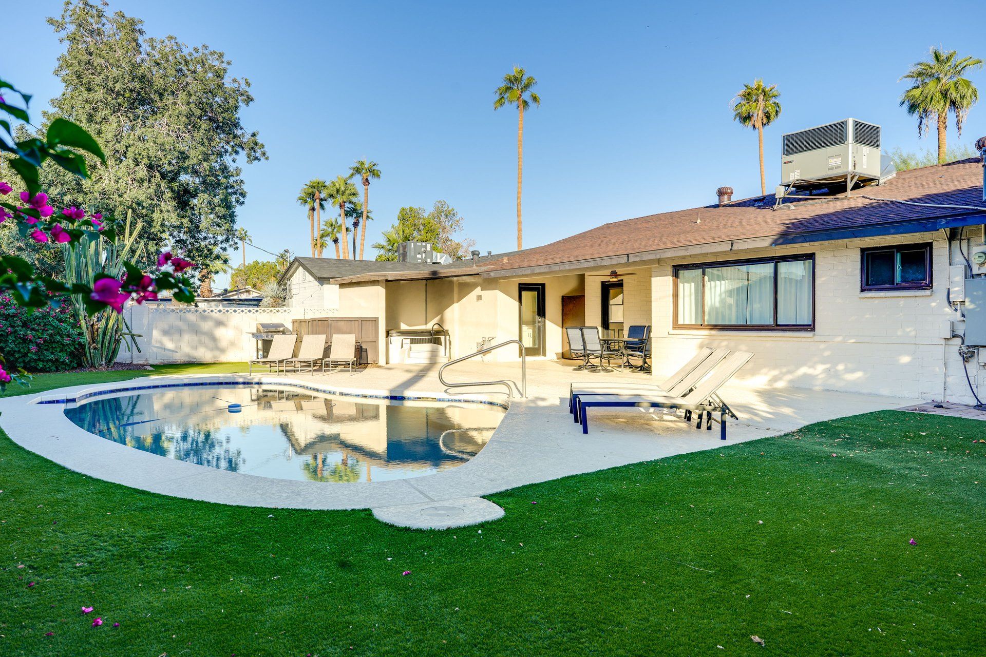 image Gather around the pool area, where comfort meets vibrant greenery in a cozy setting.