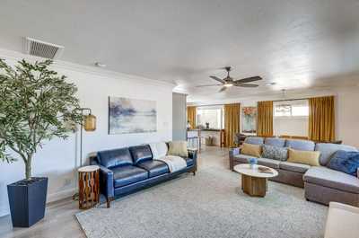 Relax in the inviting living room, complete with cozy seating and sunlight flooding through large windows.