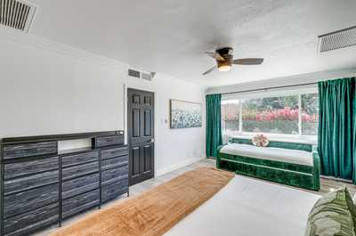 Enjoy this cozy and spacious bedroom with tasteful decor and a tranquil view of blooming flowers.