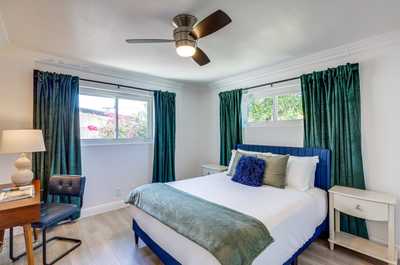 Relax in this stylish bedroom with a comfy bed and views of vibrant blooms from the window.