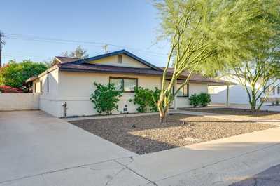 Bask in the tranquility of the yard, accented by thoughtfully placed shrubs and a clear blue sky.