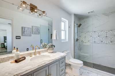 Freshen up in this stylish bathroom, featuring chic fixtures and a sparkling walk-in shower.