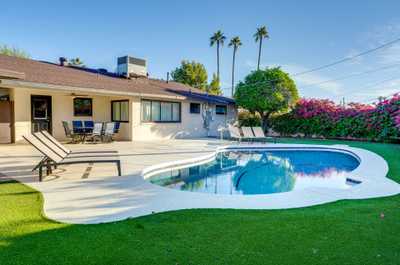 Enjoy a refreshing dip in the pool, framed by vibrant bougainvillea and palm trees.